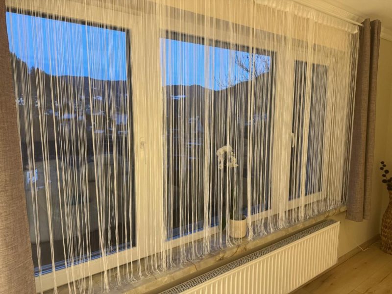 Ablak függönnyel, kilátással a kertre
